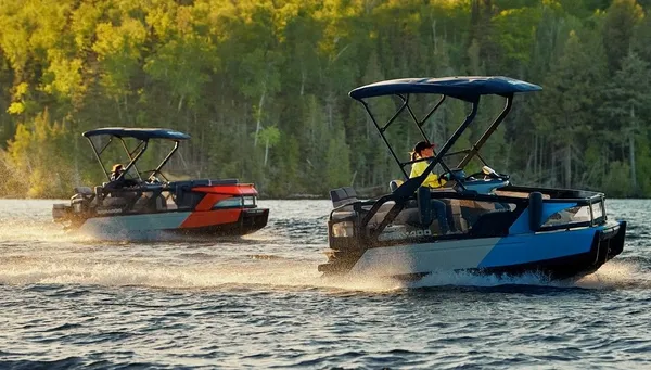 Two small pontoon boats on the river, with a view of a wooded area in the background