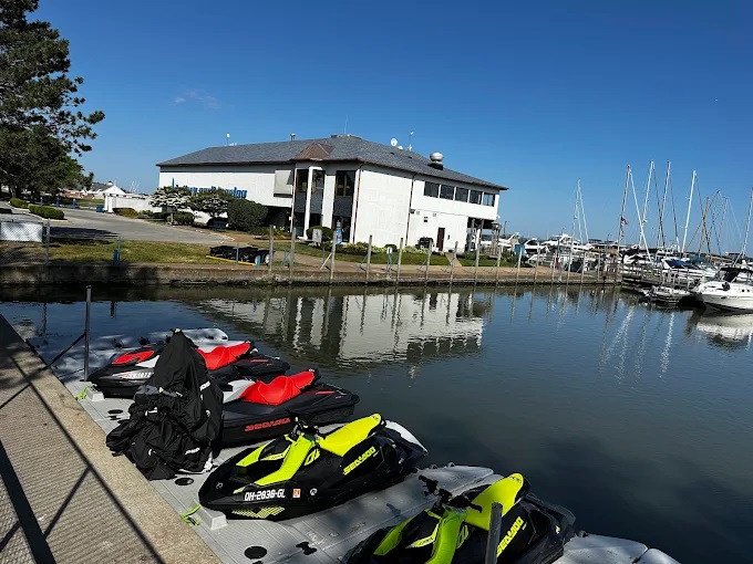 View of jet skis lined up along the dock, with the marina building in the background