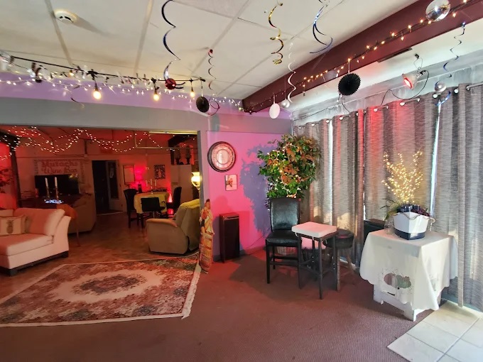View of the vibrant interior, with couches, fairy lights, and pink background lighting