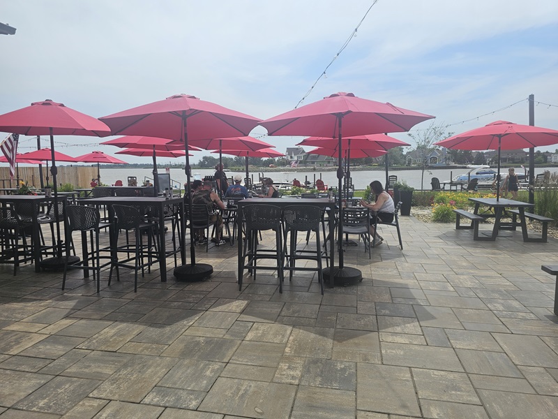 View of Pipe Creek Wharf's waterfront patio with umbrellaed tables