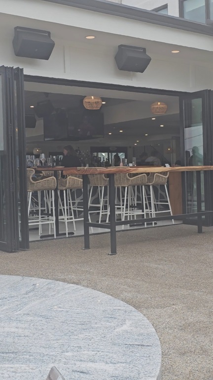 View of a long high-top table at the edge of the open indoor area