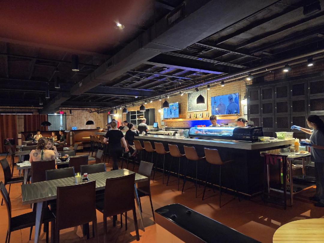 Indoor seating area with view of the restaurant tables and the sushi bar