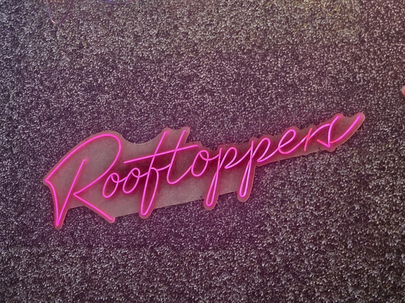 View of the representative Rooftoppers sign on the wall of Moseley's Rooftop Bar